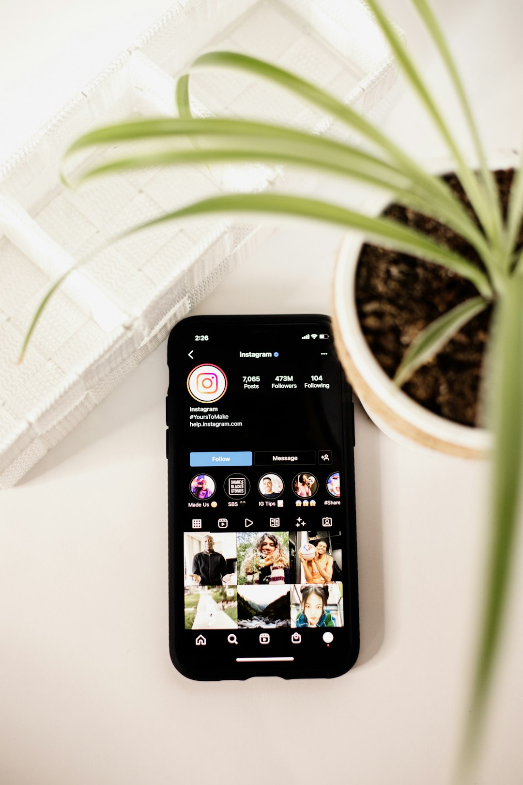 about-01 a-cell-phone-sitting-on-top-of-a-table-next-to-a-potted-plant-9qd8abqyj5w